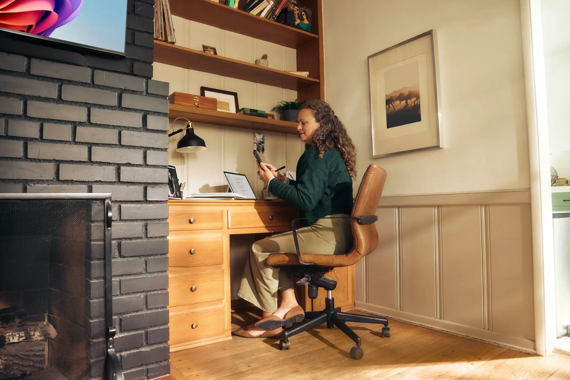 Bookkeeper working at a desk in a cosy home office, reviewing business bank statements online