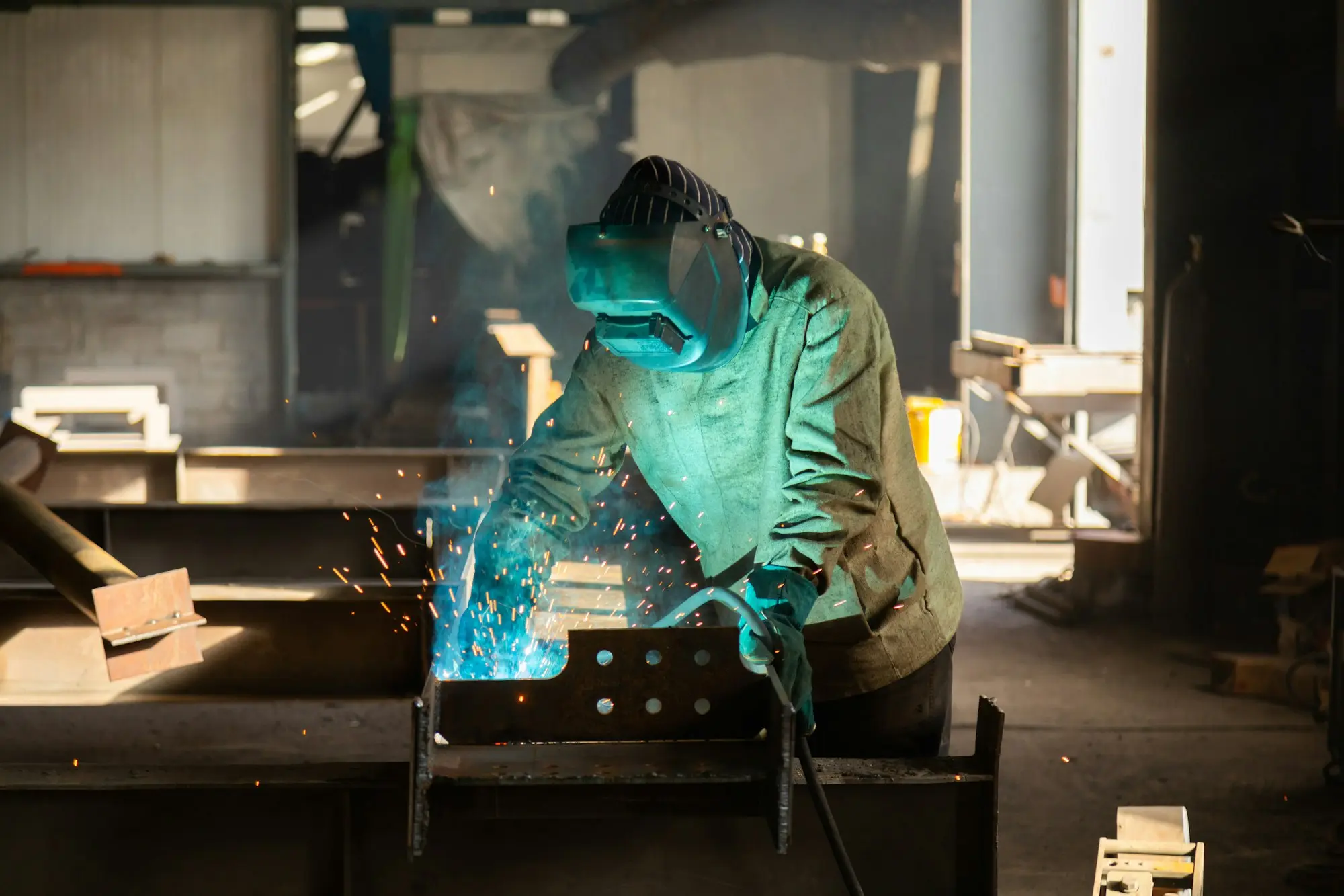 Welder working on steel in a fabrication workshop